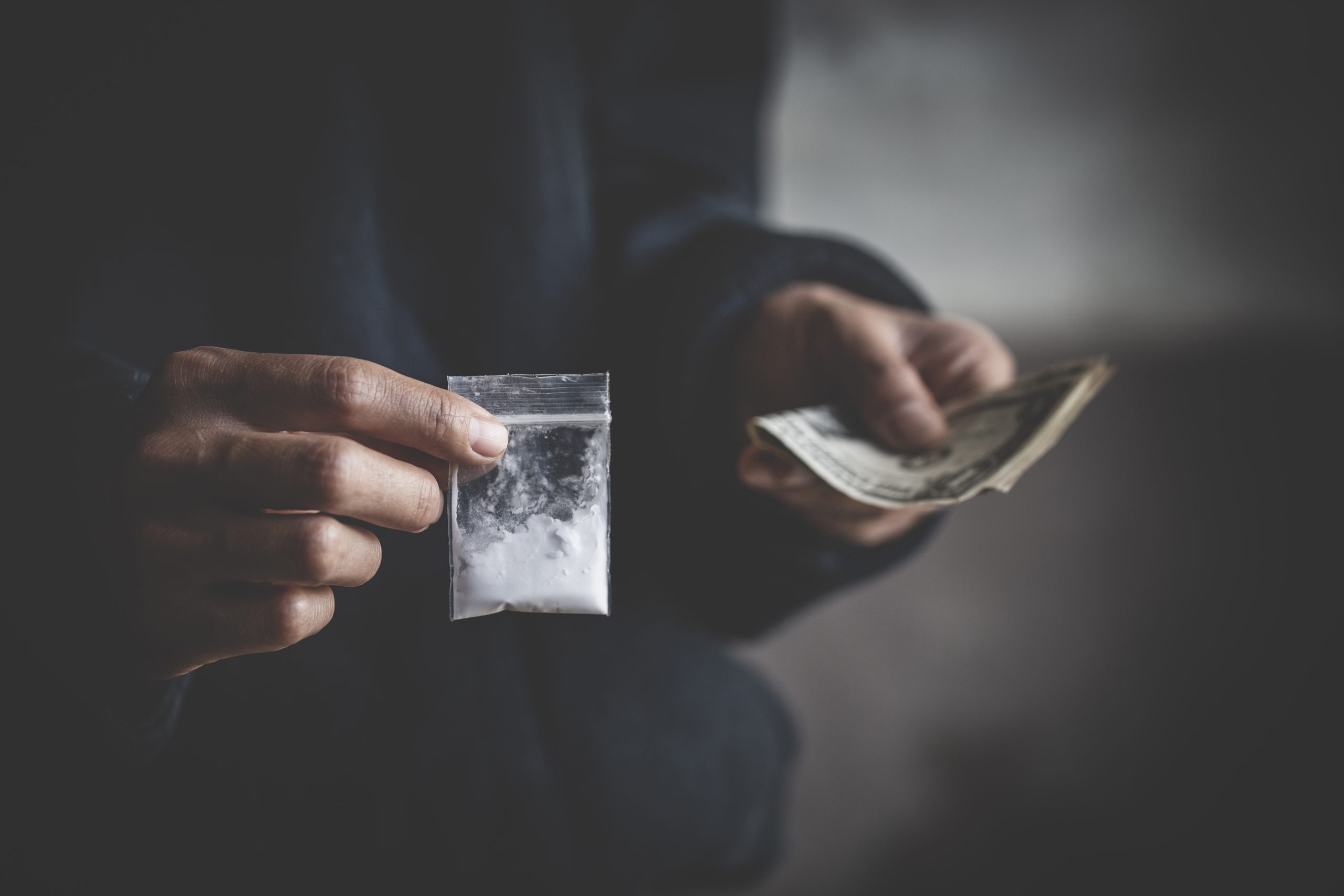 close up of addict with money buying dose, Purchase, possession and sale of drugs is punishable by law. drug trafficking, addiction and sale concept.